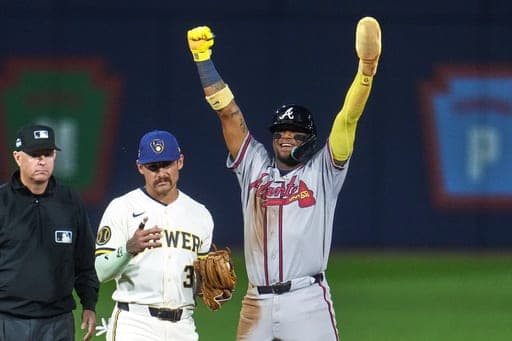 Atlanta Braves' Ronald Acuña Jr., right, celebrates next to Milwaukee Brewers shortstop Joey Ortiz (3) after stealing second base during the fifth inning of the Little League Classic baseball game in Williamsport, Pa., Sunday, Aug. 23, 2026. (AP Photo/Gene J. Puskar) (AP Photo/Gene J. Puskar)