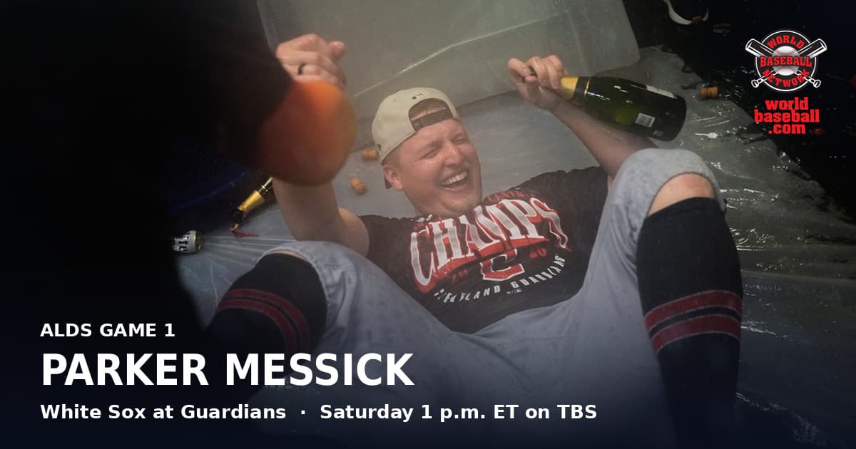 Guardians pitcher Parker Messick lies on the clubhouse floor holding a champagne bottle during the AL Central celebration.