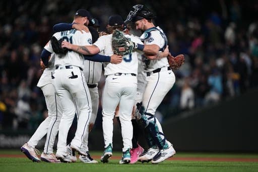 Seattle Mariners third baseman Weston Wilson, relief pitcher Gabe Speier and catcher Cal Raleigh dance to celebrate a win over the Los Angeles Angels in a baseball game, Saturday, Sept. 26, 2026, in Seattle. (AP Photo/Lindsey Wasson) (AP Photo/Lindsey Wasson)