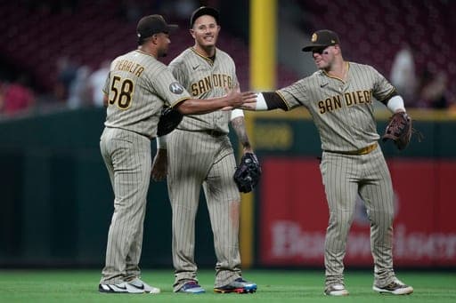 From left, San Diego Padres pitcher Wandy Peralta, third baseman Manny Machado, and first baseman Ty France, celebrate after winning a baseball game against the Cincinnati Reds, in Cincinnati, Monday, Aug. 31, 2026. (AP Photo/Carolyn Kaster) (AP Photo/Carolyn Kaster)