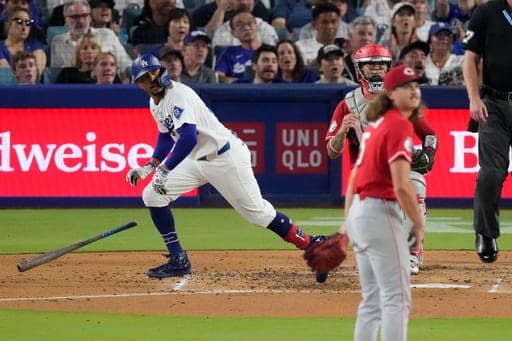 Los Angeles Dodgers' Mookie Betts, left, heads to first for a two-run home run as Cincinnati Reds pitcher Rhett Lowder, right, and catcher Will Banfield watch during the third inning of a baseball game Wednesday, Sept. 9, 2026, in Los Angeles. (AP Photo/Mark J. Terrill) (AP Photo/Mark J. Terrill)