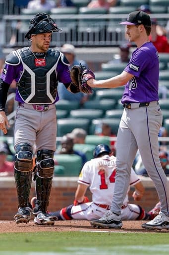 Colorado Rockies catcher Brett Sullivan, left, celebrates with pitcher Ryan Feltner (18) after tagging out Atlanta Braves' Mauricio Dubón (14) during the sixth inning of a baseball game, Sunday, Aug. 30, 2026, in Atlanta. (AP Photo/Erik S. Lesser) (AP Photo/Erik S. Lesser)