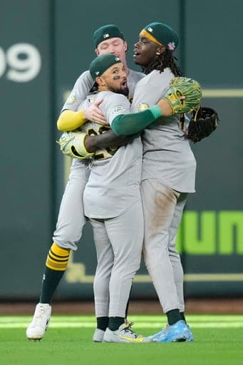 Athletics' Carlos Cortes, center, Lawrence Butler, right, and Henry Bolte celebrate after a baseball game against the Houston Astros Sunday, Aug. 23, 2026, in Houston. (AP Photo/David J. Phillip) (AP Photo/David J. Phillip)