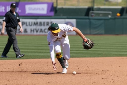 Athletics shortstop Jacob Wilson (5) attempts to field a ball during the fourth inning of a baseball game against the Texas Rangers, Sunday, Aug. 16, 2026, in West Sacramento, Calif. (AP Photo/Sara Nevis) (AP Photo/Sara Nevis)