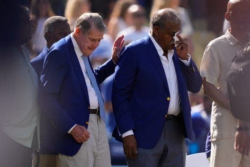 Former Los Angeles Dodger Reggie Smith, right, wipes his eyes as former Dodgers owner Peter O'Malley pats him on the back after Smith was inducted into the Legends of Dodger Baseball prior to a baseball game between the Dodgers and the Milwaukee Brewers, Saturday, Aug. 15, 2026, in Los Angeles. (AP Photo/Mark J. Terrill) (AP Photo/Mark J. Terrill)