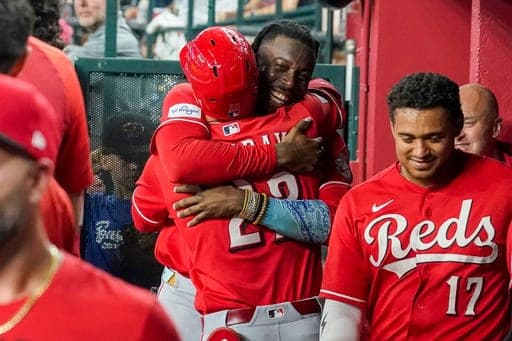 Cincinnati Reds' Elly De La Cruz, center right, hugs JJ Bleday, after Bleday hit for the cycle during the sixth inning of a baseball game against the Arizona Diamondbacks, Saturday, Aug. 22, 2026, in Phoenix. (AP Photo/Darryl Webb) (AP Photo/Darryl Webb)
