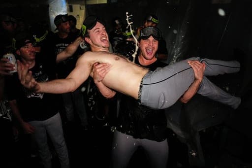 Chicago White Sox's Kyle Teel is hoisted by Mike Vasil in the clubhouse after clinching a playoff spot following their baseball game against the Kansas City Royals, Thursday, Sept. 24, 2026, in Kansas City, Mo. (AP Photo/Charlie Riedel) (AP Photo/Charlie Riedel)