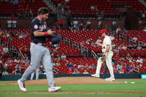 St. Louis Cardinals' Gordon Graceffo, right, walks to the top of the mound as Washington Nationals' Jacob Young, left, advances to first base due to catcher's interference during the 11th inning of a baseball game Saturday, Sept. 19, 2026, in St. Louis. (AP Photo/Scott Kane) (AP Photo/Scott Kane)