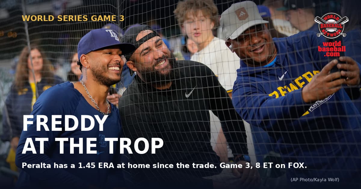 Freddy Peralta, in a Tampa Bay Rays uniform, leans toward the stands to pose for a photo with fans at American Family Field before Game 2 of the World Series.