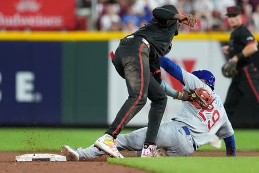 Chicago Cubs' Michael Busch, right, is tagged out by Cincinnati Reds shortstop Elly De La Cruz, left, while trying to steal second base to end a baseball game, Friday, Sept. 18, 2026, in Cincinnati. (AP Photo/Kareem Elgazzar) (AP Photo/Kareem Elgazzar)