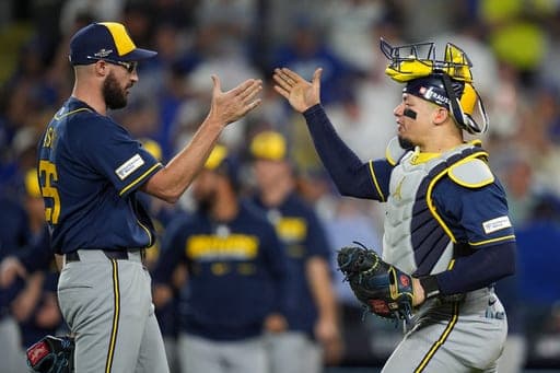 Milwaukee Brewers catcher William Contreras, right, and pitcher Aaron Ashby (26) celebrate after the final out of Game 4 of baseball's National League Championship Series between the Milwaukee Brewers and the Los Angeles Dodgers, Thursday, Oct. 15, 2026, in Los Angeles. (AP Photo/Gregory Bull) (AP Photo/Gregory Bull)