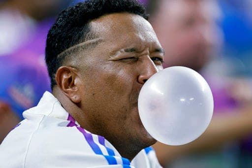Kansas City Royals' Salvador Perez blows a bubble as he watches from the dugout during a baseball game against the Detroit Tigers in Kansas City, Mo., Friday, Aug. 21, 2026. (AP Photo/Colin E. Braley) (AP Photo/Colin E. Braley)