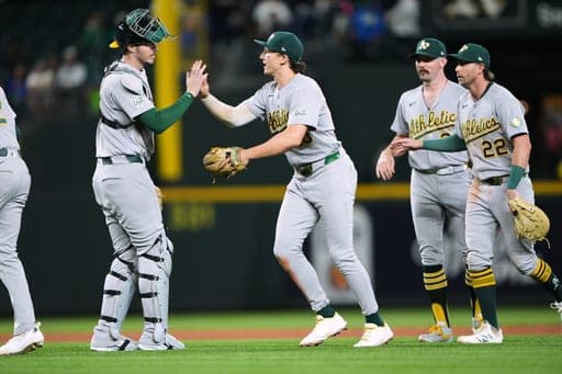 From left, Athletics catcher Jonah Heim, third baseman Zack Gelof, relief pitcher Hogan Harris and first baseman Jeff McNeil celebrate a win over the Seattle Mariners in a baseball game, Friday, Sept. 4, 2026, in Seattle. (AP Photo/Lindsey Wasson) (AP Photo/Lindsey Wasson)
