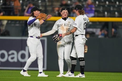 Colorado Rockies center fielder Cole Carrigg, center, is congratulated by left fielder Jake McCarthy, left, and right fielder Zac Veen after defeating the San Diego Padres in a baseball game Tuesday, Sept. 15, 2026, in Denver. (AP Photo/David Zalubowski) (AP Photo/David Zalubowski)
