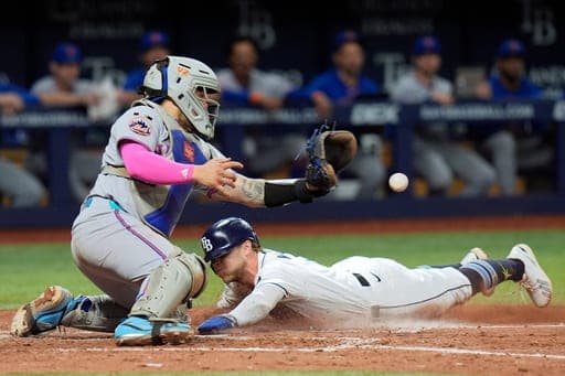 Tampa Bay Rays' Taylor Walls scores ahead of the throw to New York Mets catcher Francisco Alvarez on an RBI single by Liam Hicks during the eighth inning of a baseball game Monday, Aug. 31, 2026, in St. Petersburg, Fla. (AP Photo/Chris O'Meara) (AP Photo/Chris O'Meara)
