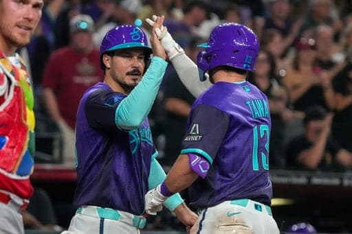 Arizona Diamondbacks' Nolan Arenado, second from right, high-fives Tim Tawa (13) after Tawa's home run in the sixth inning of a baseball game against the Cincinnati Reds, Saturday, Aug. 22, 2026, in Phoenix. (AP Photo/Darryl Webb) (AP Photo/Darryl Webb)