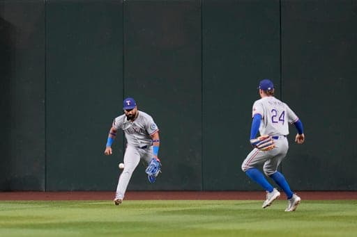 Texas Rangers center fielder Ezequiel Duran, left, and Rangers right fielder Brandon Nimmo (24) are unable to make a play on a triple hit by Arizona Diamondbacks' Tim Tawa during the third inning of a baseball game, Saturday, Sept. 12, 2026, in Phoenix. (AP Photo/Ross D. Franklin) (AP Photo/Ross D. Franklin)