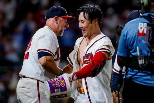 Atlanta Braves pinch-hitter Ha-Seong Kim, right, is congratulated by manager Walt Weiss, left, after Kim hit a game-winning RBI single against the Los Angeles Dodgers during the ninth inning of a baseball game, Wednesday, Aug. 26, 2026, in Atlanta. (AP Photo/Erik S. Lesser) (AP Photo/Erik S. Lesser)