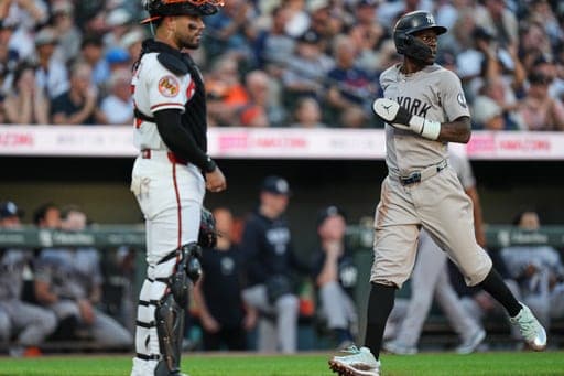 New York Yankees' Jazz Chisholm Jr., right, scores past Baltimore Orioles catcher Carlos Narváez on an RBI hit by Ryan McMahon during the second inning of a baseball game, Wednesday, Aug. 19, 2026, in Baltimore. (AP Photo/Stephanie Scarbrough) (AP Photo/Stephanie Scarbrough)