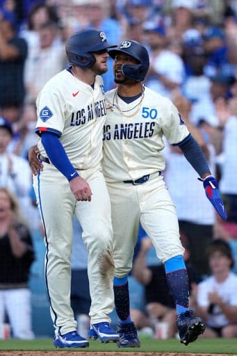Los Angeles Dodgers' Max Muncy, left, and Mookie Betts celebrate after scoring on a single by Kyle Tucker during the fifth inning of a baseball game against the Pittsburgh Pirates, Saturday, Aug. 22, 2026, in Los Angeles. (AP Photo/Mark J. Terrill) (AP Photo/Mark J. Terrill)