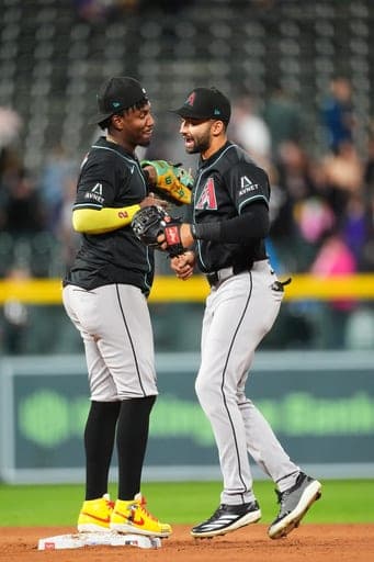 Arizona Diamondbacks shortstop Geraldo Perdomo, left, celebrates with center fielder Jordan Lawlar after defeating the Colorado Rockies in a baseball game Wednesday, Sept. 23, 2026, in Denver. (AP Photo/David Zalubowski) (AP Photo/David Zalubowski)