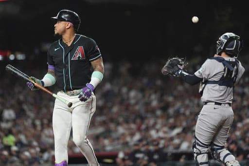 Arizona Diamondbacks' Ketel Marte, left, walks back to the dugout after striking out as New York Yankees catcher Austin Wells throws the ball to the first baseman during the first inning of a baseball game, Friday, Sept. 18, 2026, in Phoenix. (AP Photo/Ross D. Franklin) (AP Photo/Ross D. Franklin)