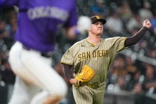 San Diego Padres relief pitcher Adrian Morejon, back, throws to first base to put out Colorado Rockies' TJ Rumfield to end the eighth inning of a baseball game Monday, Sept. 14, 2026, in Denver. (AP Photo/David Zalubowski) (AP Photo/David Zalubowski)