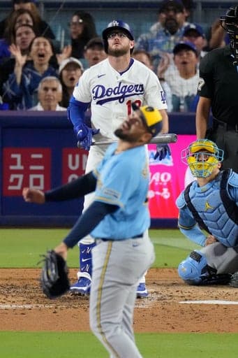 Los Angeles Dodgers' Max Muncy, left, heads to first for a three-run home run as Milwaukee Brewers pitcher Antonio Senzatela, center, and catcher William Contreras watch during the sixth inning of a baseball game Thursday, Aug. 13, 2026, in Los Angeles. (AP Photo/Mark J. Terrill) (AP Photo/Mark J. Terrill)