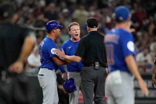 Chicago Cubs' Pete Crow-Armstrong, center, and Cubs third base coach Quintin Berry (0) argue with umpire Lance Barrett during the sixth inning of a baseball game against the Arizona Diamondbacks, Wednesday, Aug. 26, 2026, in Phoenix. (AP Photo/Ross D. Franklin) (AP Photo/Ross D. Franklin)