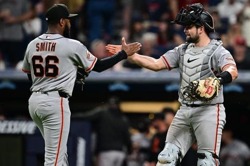 San Francisco Giants relief pitcher Dylan Smith, left, is congratulated by catcher Drew Cavanaugh after the Giants defeated the Cleveland Guardians in a baseball game, Wednesday, Aug. 19, 2026, in Cleveland. (AP Photo/David Dermer) (AP Photo/David Dermer)
