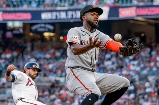 San Francisco Giants third baseman Osleivis Basabe, right, bobbles a ground ball hit by Atlanta Braves' Ronald Acuña Jr. (not shown) as Austin Riley, left, slides safely into third during the fifth inning of a baseball game, Monday, Aug. 31, 2026, in Atlanta. (AP Photo/Erik S. Lesser) (AP Photo/Erik S. Lesser)