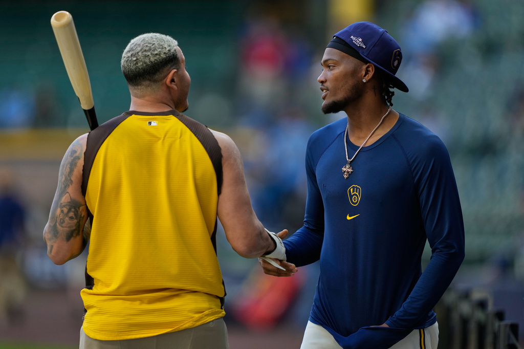 Padres third baseman Manny Machado talks with Brewers reliever Abner Uribe before Game 2.